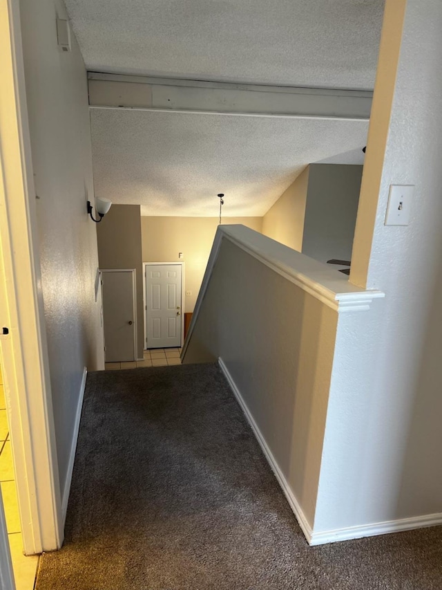 hallway featuring light carpet and a textured ceiling