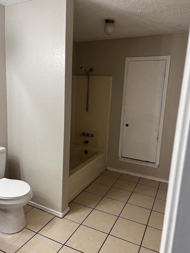 bathroom featuring toilet, a textured ceiling, tile patterned flooring, and shower / bath combination