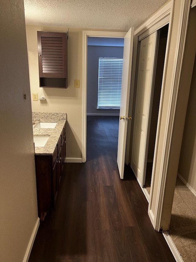 bathroom with hardwood / wood-style flooring, a textured ceiling, and vanity