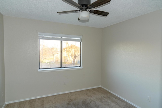 empty room featuring light carpet, ceiling fan, and a textured ceiling