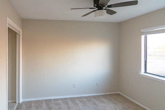 spare room featuring ceiling fan and light colored carpet