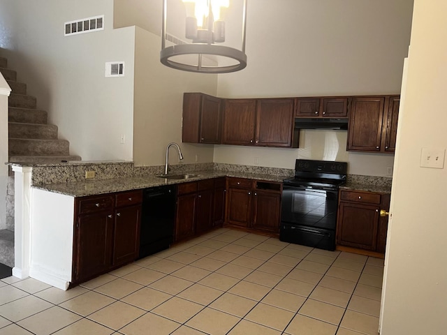 kitchen with black appliances, kitchen peninsula, sink, light tile patterned flooring, and light stone countertops