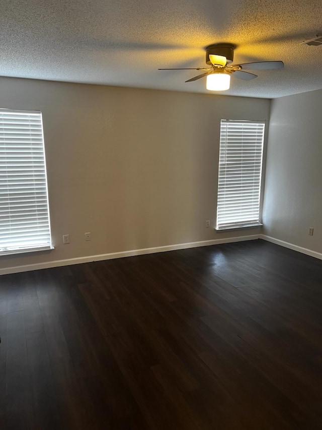 spare room featuring ceiling fan, dark hardwood / wood-style floors, and a textured ceiling