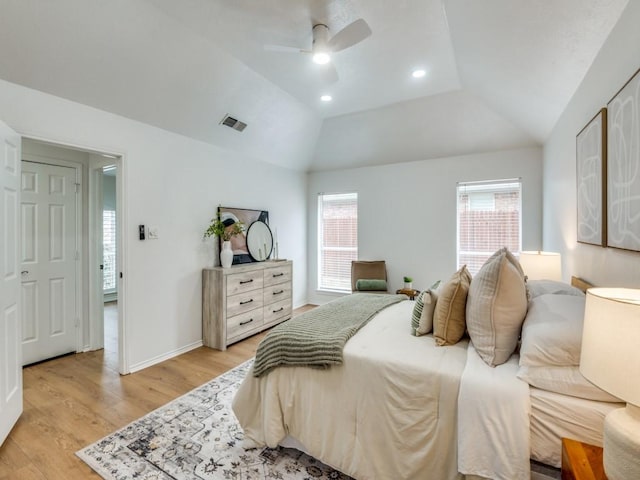 bedroom with ceiling fan, lofted ceiling, light hardwood / wood-style flooring, and multiple windows