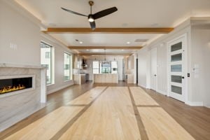 unfurnished living room with hardwood / wood-style floors, ceiling fan, a premium fireplace, crown molding, and beamed ceiling