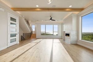 unfurnished living room with a fireplace, beam ceiling, light hardwood / wood-style flooring, and ceiling fan