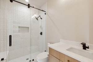 bathroom featuring toilet, vanity, and an enclosed shower