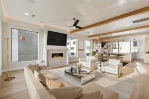 living room featuring ceiling fan, light hardwood / wood-style floors, and beamed ceiling