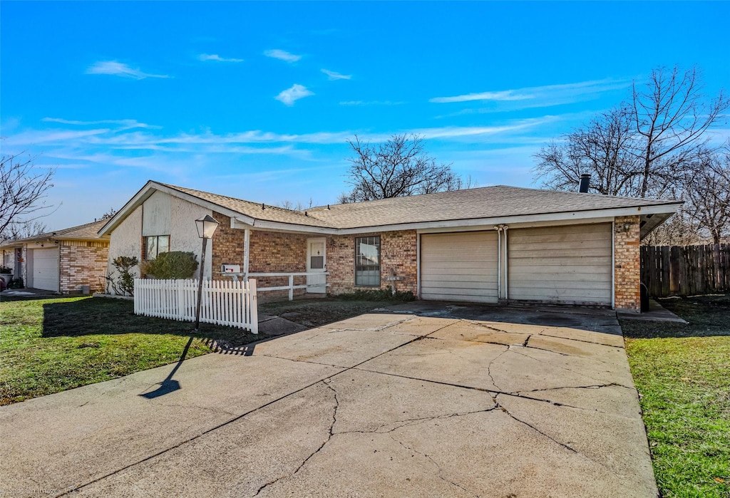 ranch-style home featuring a garage and a front yard