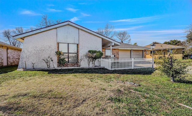 back of property with a garage and a yard