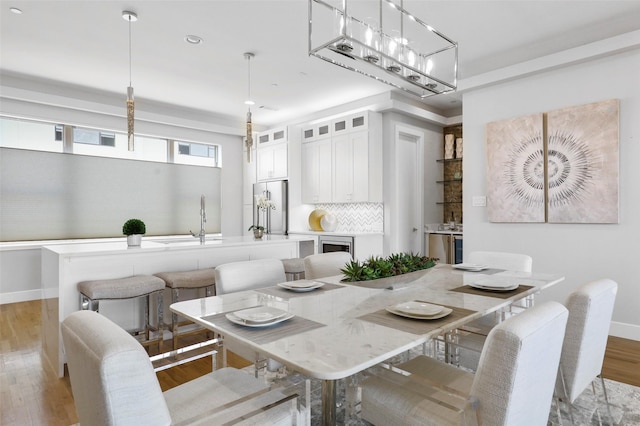 dining room with light hardwood / wood-style floors and sink