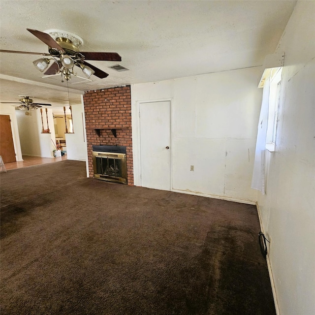unfurnished living room featuring ceiling fan, a textured ceiling, carpet, and a fireplace
