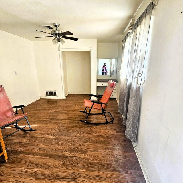 living area featuring ceiling fan and dark hardwood / wood-style floors