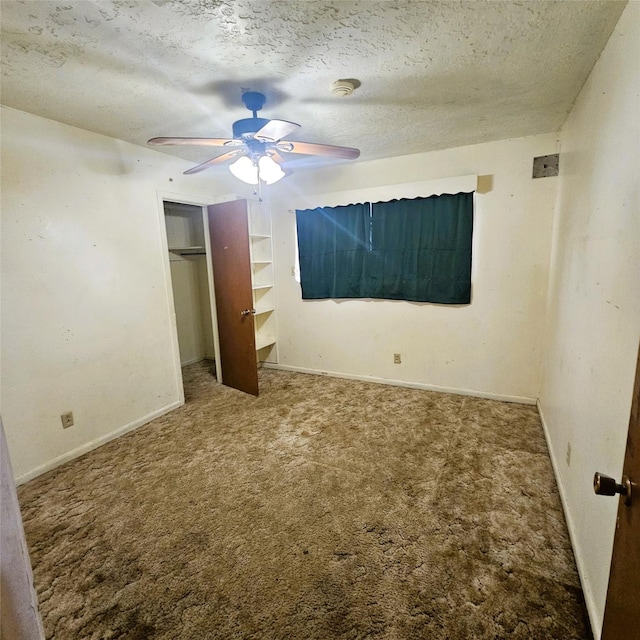 unfurnished bedroom with ceiling fan, carpet floors, and a textured ceiling