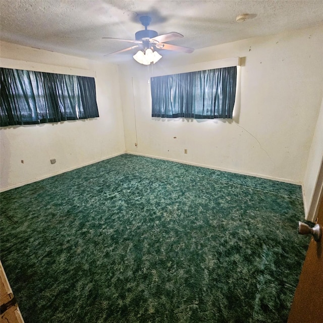carpeted spare room featuring ceiling fan and a textured ceiling