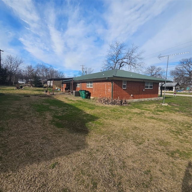view of side of home featuring a lawn and a carport