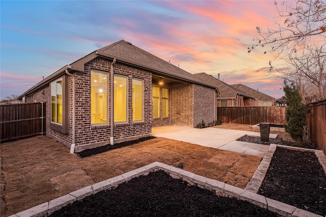 back house at dusk with a patio