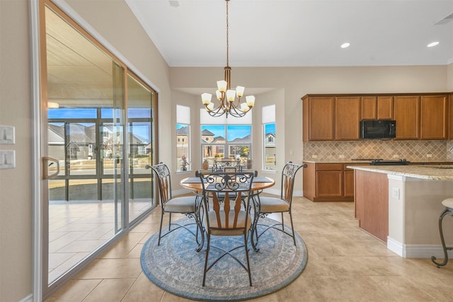 dining space featuring light tile patterned floors, a notable chandelier, and a healthy amount of sunlight