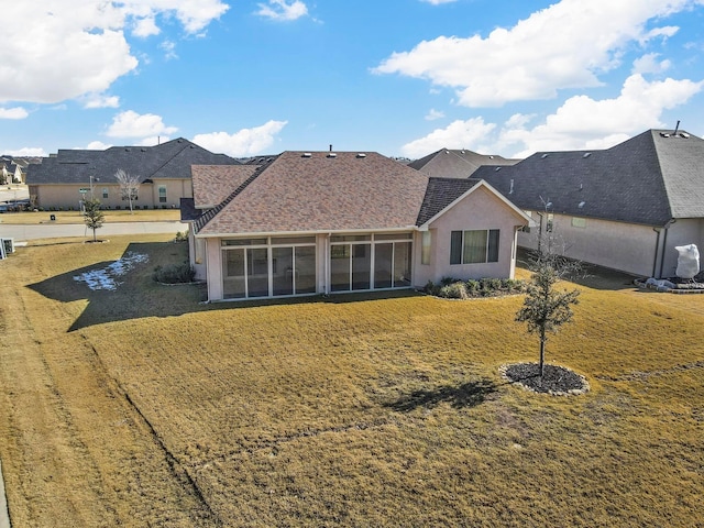 rear view of house with a sunroom and a yard