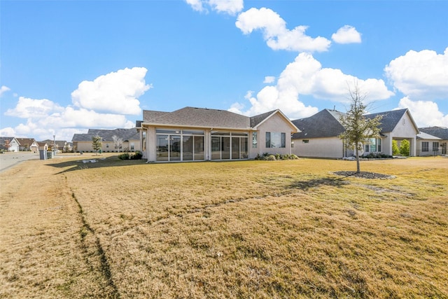 rear view of house featuring a yard