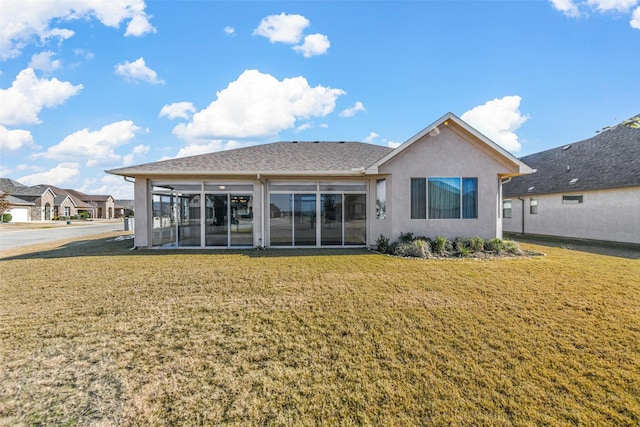 rear view of house with a sunroom and a yard