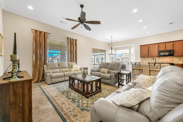 living room with light tile patterned flooring and ceiling fan with notable chandelier