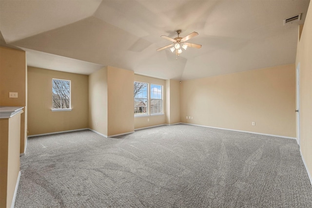 interior space featuring ceiling fan, vaulted ceiling, and light carpet