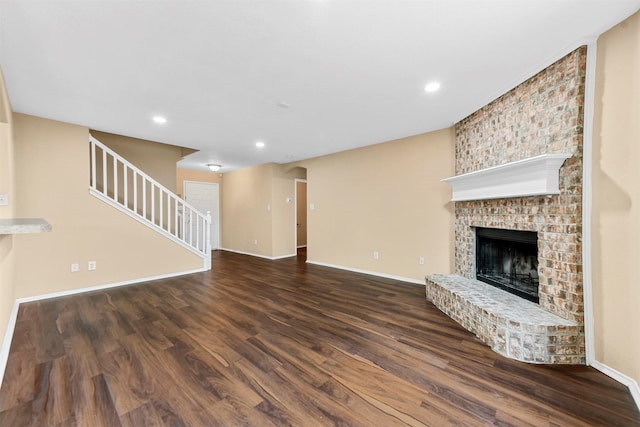 unfurnished living room featuring a fireplace and dark hardwood / wood-style floors