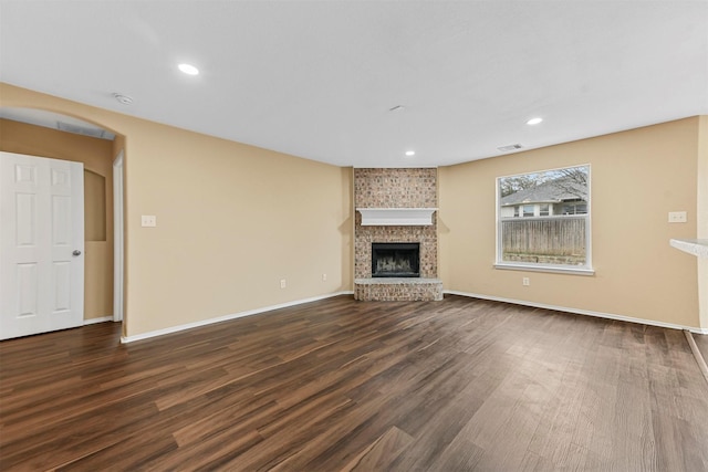 unfurnished living room featuring dark hardwood / wood-style floors and a fireplace