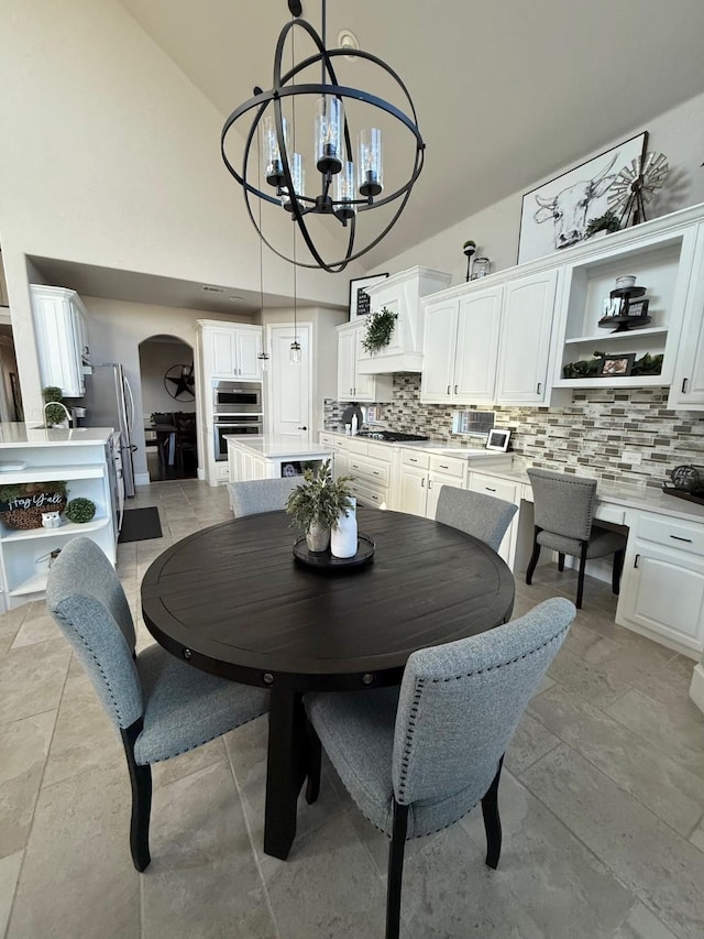 dining area featuring a chandelier and a towering ceiling