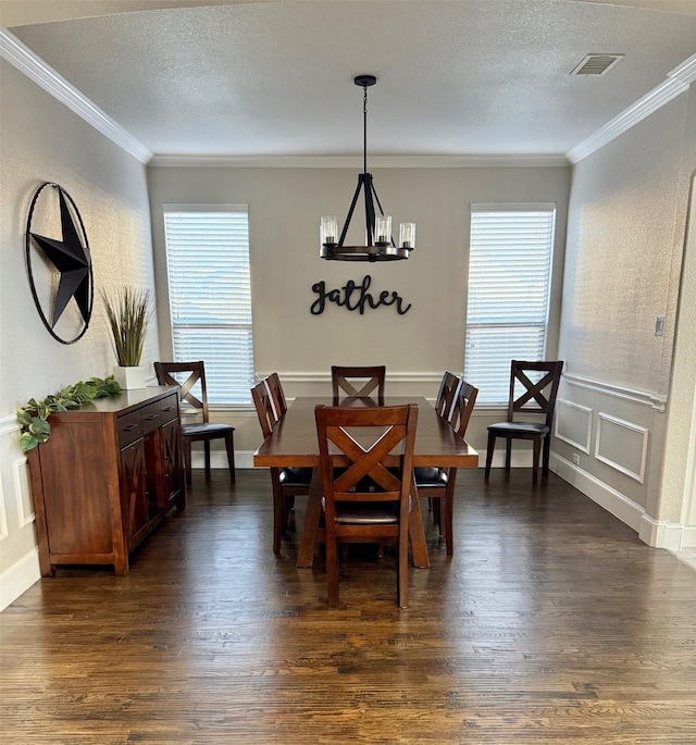 dining area with a wealth of natural light, dark hardwood / wood-style flooring, crown molding, and a notable chandelier