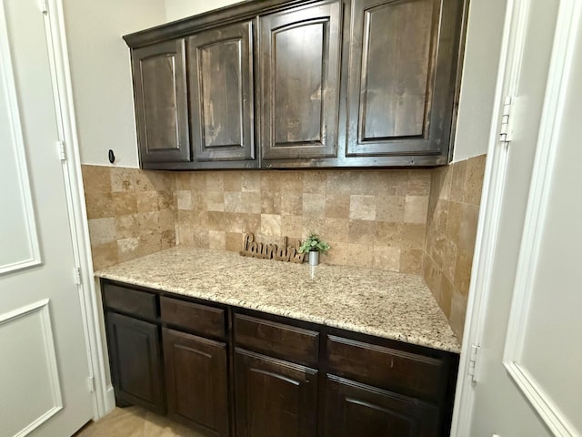 interior space with light stone counters and dark brown cabinetry