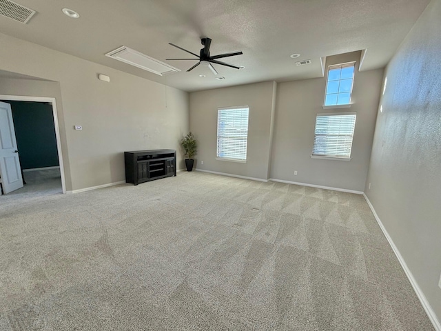 unfurnished living room featuring light carpet and ceiling fan