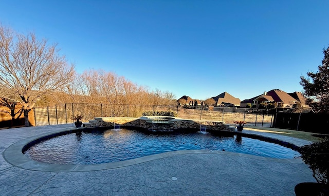 view of swimming pool featuring pool water feature and an in ground hot tub