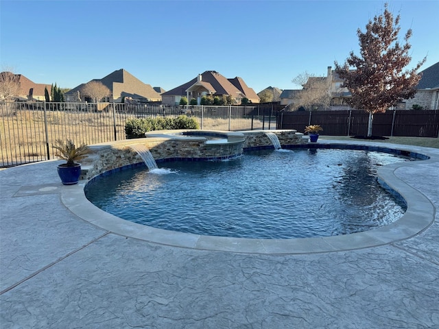 view of swimming pool featuring pool water feature and an in ground hot tub