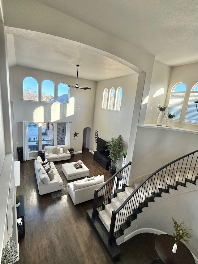 living room with ceiling fan, a wealth of natural light, and dark hardwood / wood-style floors