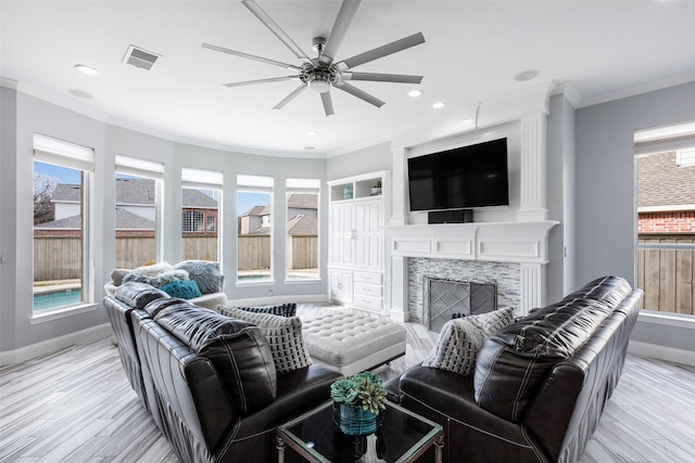 living room featuring ornamental molding, plenty of natural light, and light wood-type flooring