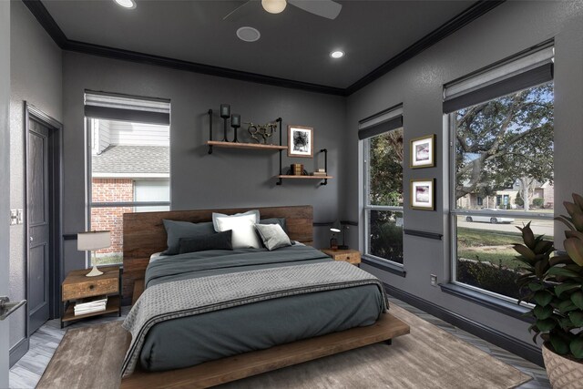 bedroom with multiple windows, ornamental molding, ceiling fan, and light hardwood / wood-style floors