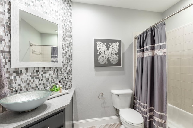 bathroom with tasteful backsplash, baseboards, toilet, shower / bath combination with curtain, and vanity