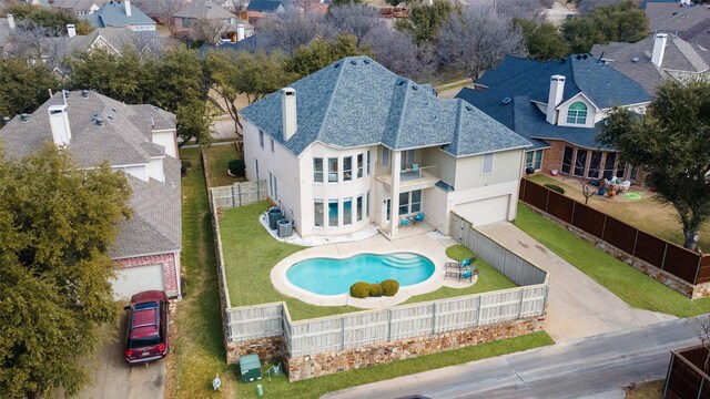 back of house with a balcony, a yard, a fenced in pool, and a patio area