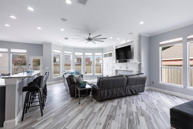 living room featuring ornamental molding, ceiling fan, and light hardwood / wood-style flooring