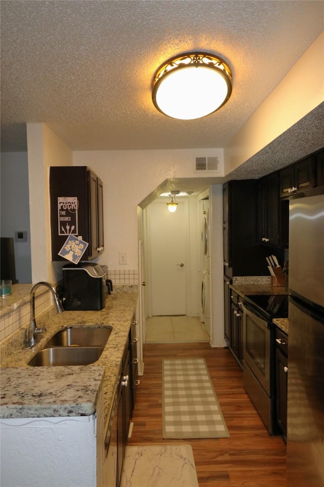 kitchen with ceiling fan, appliances with stainless steel finishes, sink, and hardwood / wood-style floors