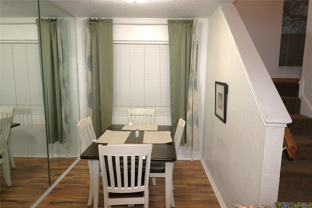 dining area featuring dark hardwood / wood-style flooring and a textured ceiling