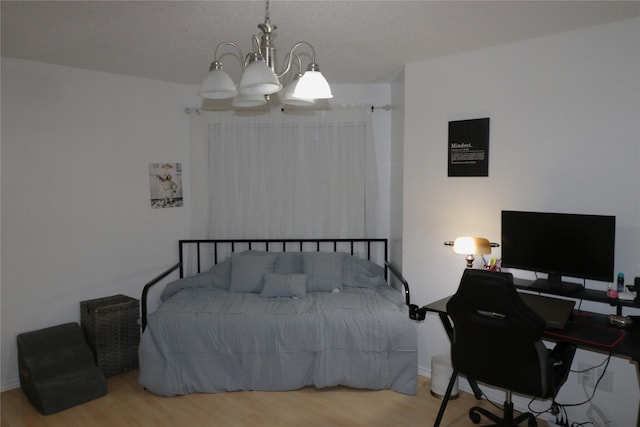 bedroom with wood-type flooring and an inviting chandelier