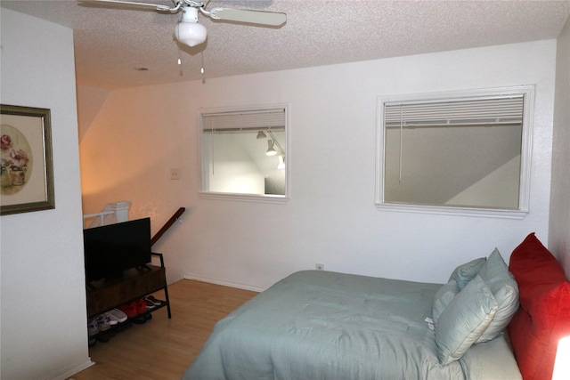 bedroom featuring a textured ceiling, ceiling fan, and wood-type flooring