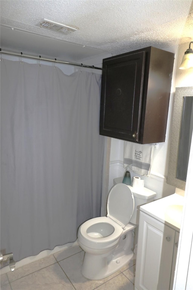 bathroom featuring a textured ceiling, vanity, and tile patterned flooring