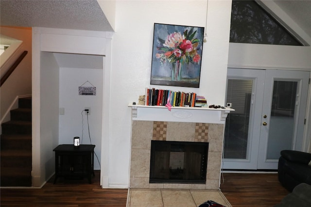 living room with wood-type flooring, french doors, and a tile fireplace