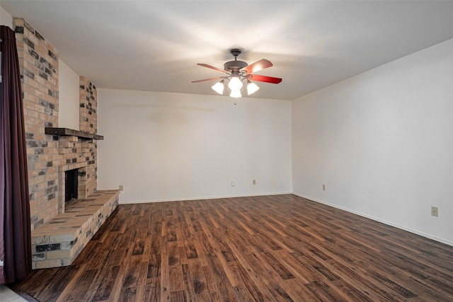 unfurnished living room with a brick fireplace, ceiling fan, baseboards, and wood finished floors