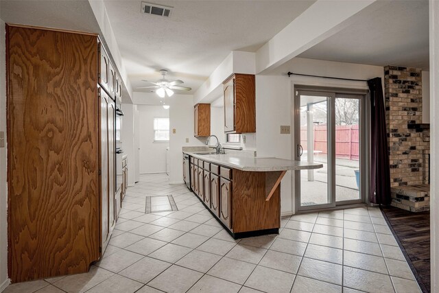 kitchen with dishwasher, sink, kitchen peninsula, independent washer and dryer, and ceiling fan