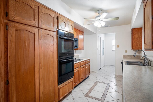 kitchen with black appliances, light tile patterned floors, and sink